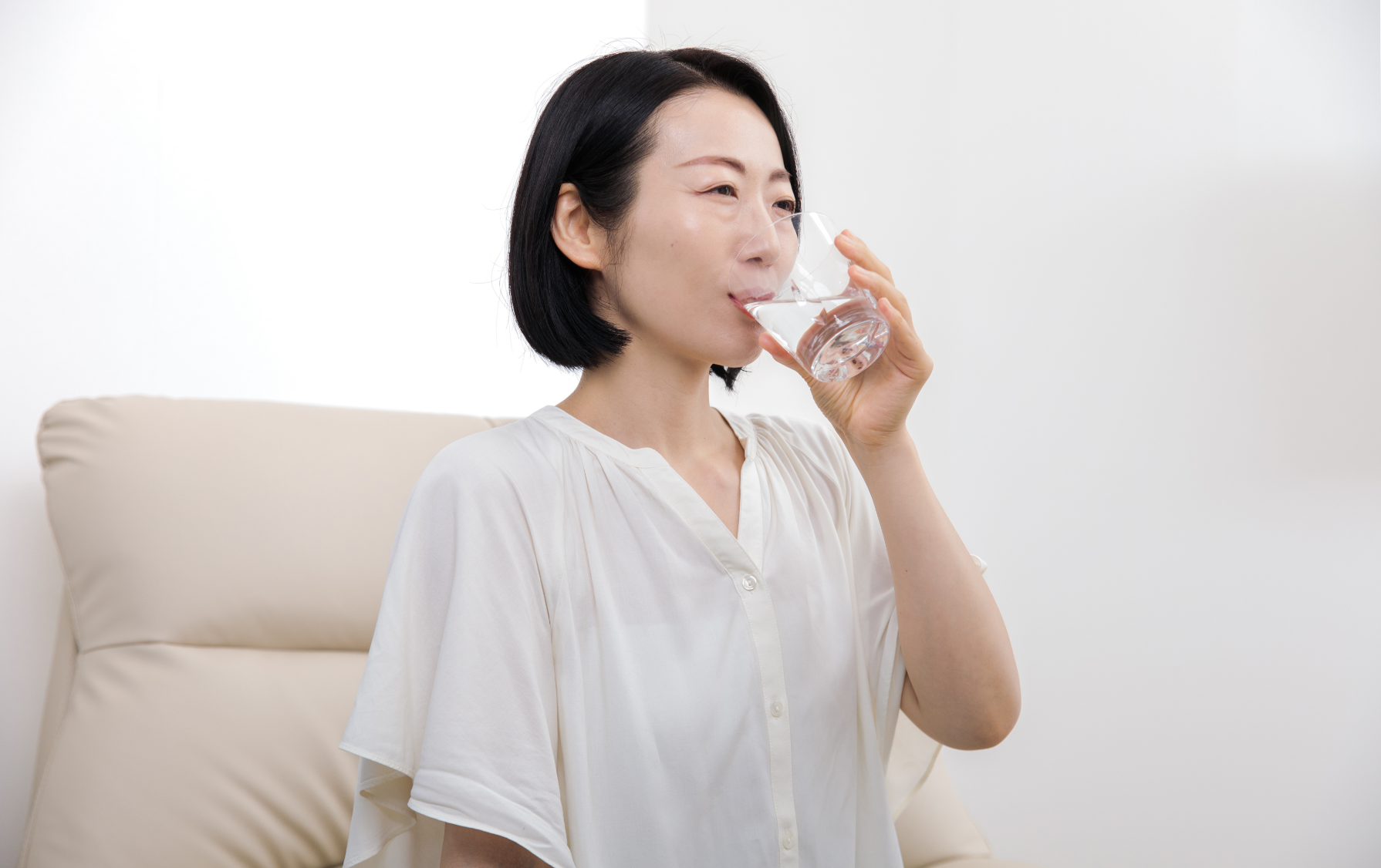 コップの水を飲んでいる女性